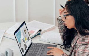 Woman wearing glasses in front of a computer